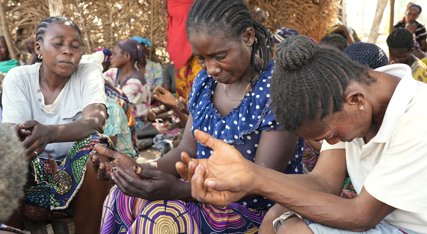 women praying in an IDP camp in Nigeria