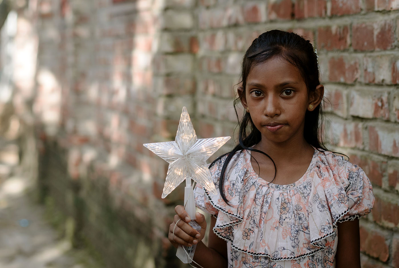 Rumana, a 9 year old girl in Bangldesh, holds a Christmas star