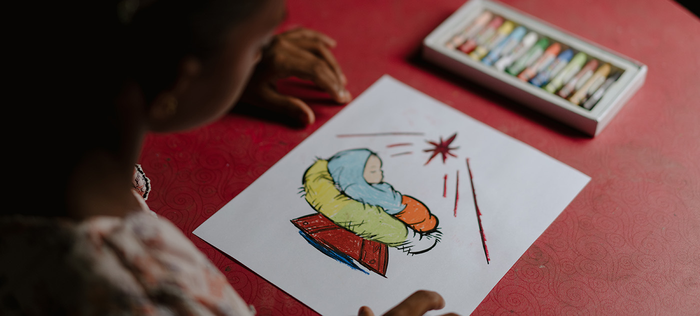 Rumana, a 9 year old girl in Bangladesh, colors a picture of the Nativity