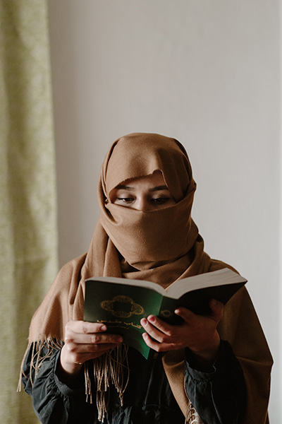 A woman in Islamic garb reads the Bible